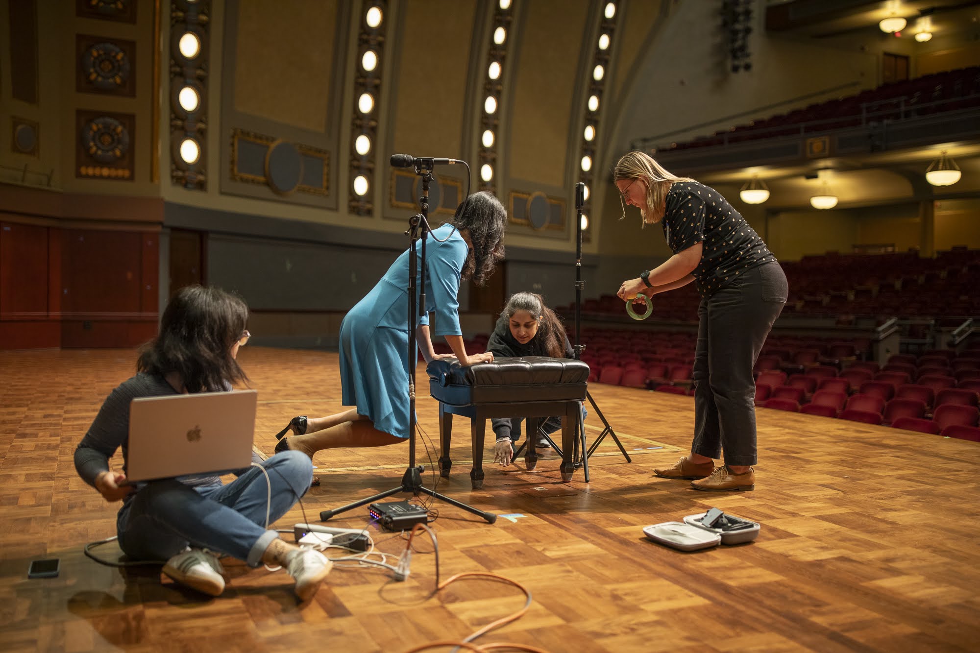 Team on the Hill Auditorium stage setting up audio and capture equipment